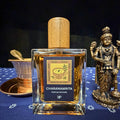 Fragrance bottle labeled 'Charanamrita' with a wooden cap on a dark background
