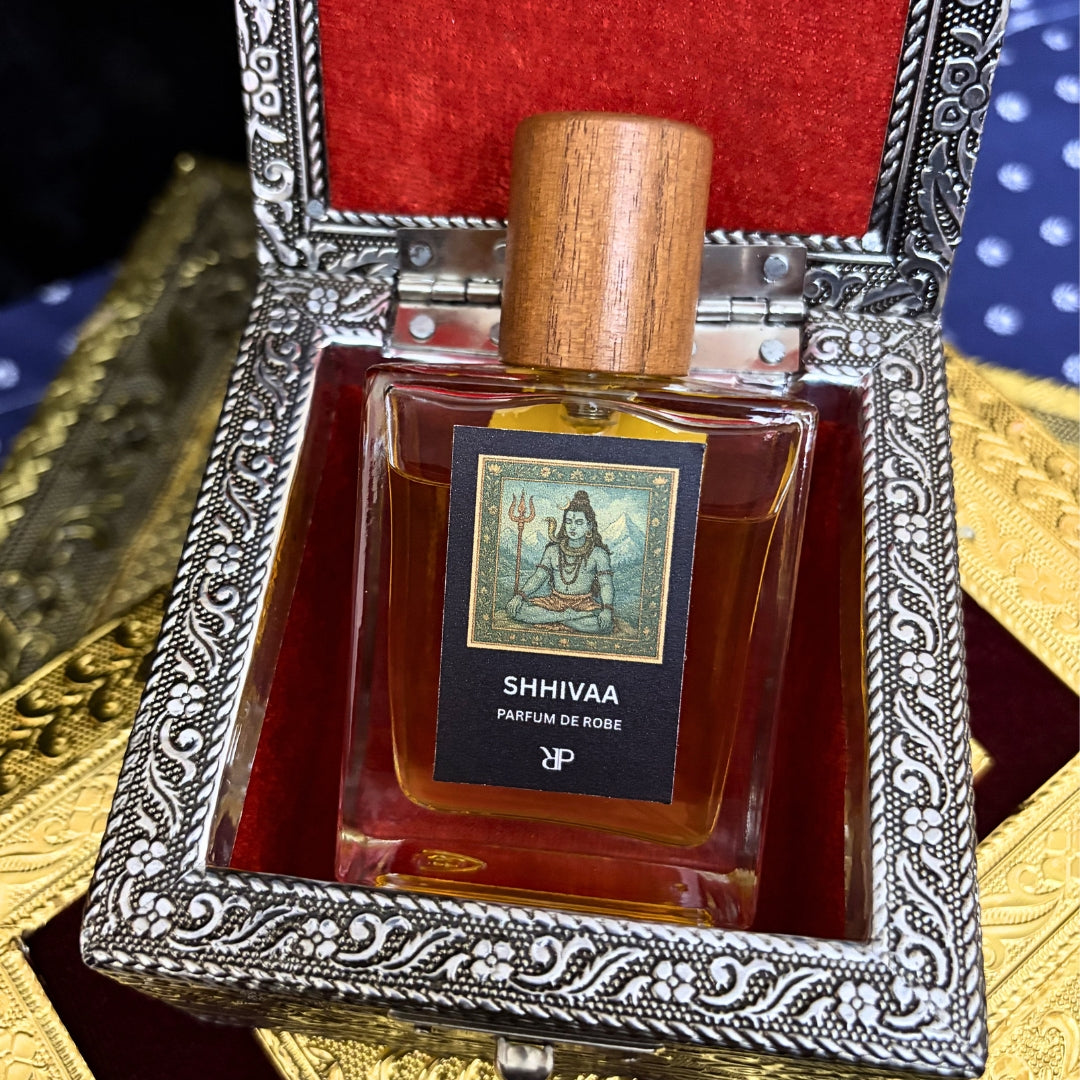 Perfume bottle labeled 'Shhiva' in an ornate silver and red box.