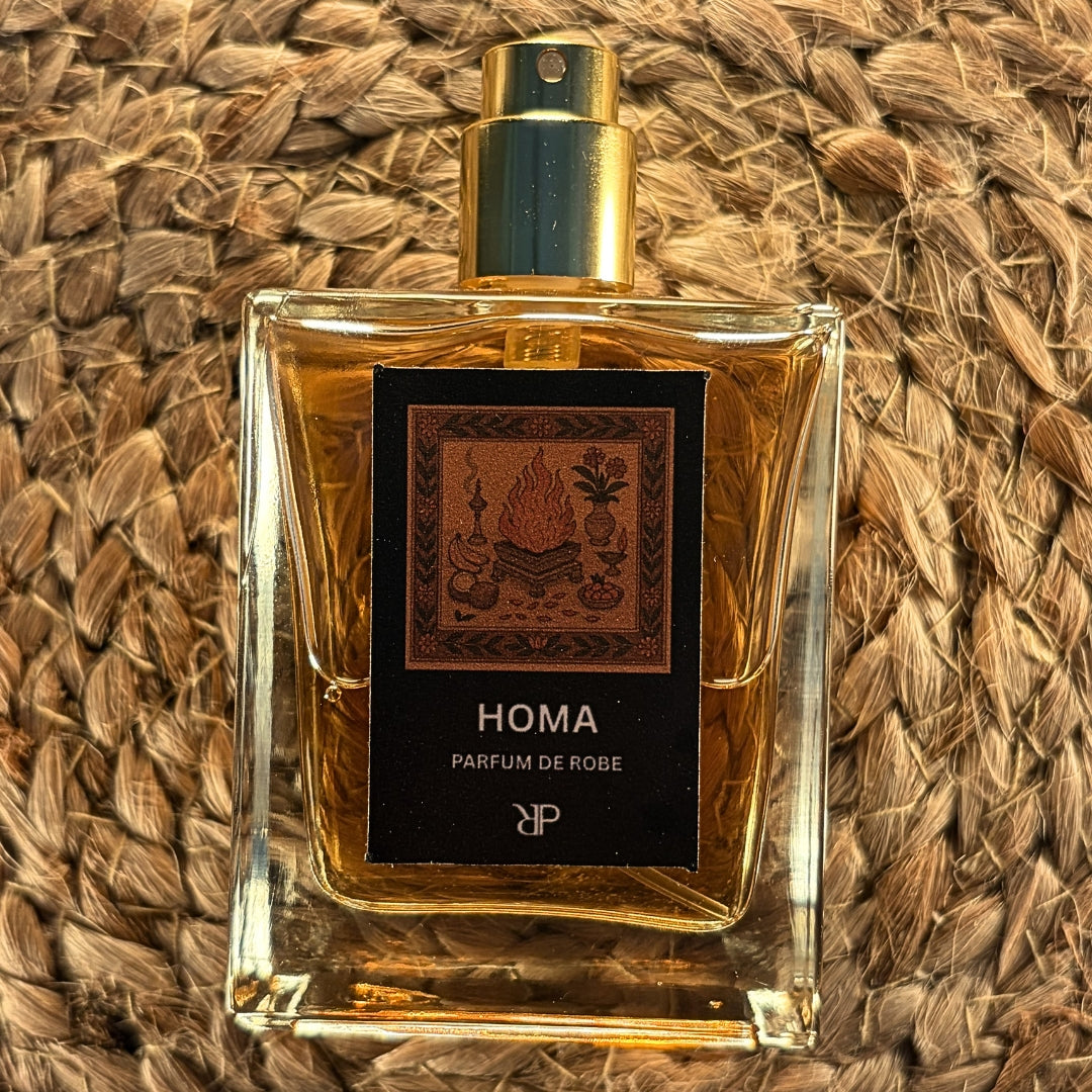 Fragrance bottle labeled 'Homa - Parfum de Robe' on a woven surface
